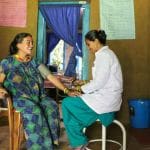 Eine Hebamme untersucht eine nepalesische Mutter im Geburtshaus von Back to Life.
